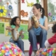 A music therapist plays the tambourine with a child in a group session.