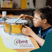 Young music therapy client playing the drum